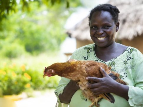 woman in uganda holding chicken